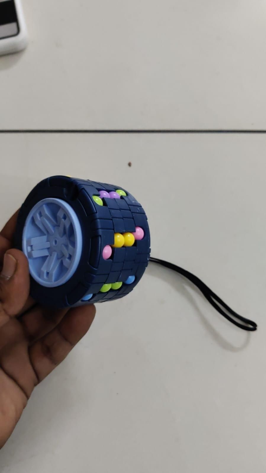 Puzzle Toy Hand holding a blue puzzle toy with colorful beads and text encouraging brain exercise